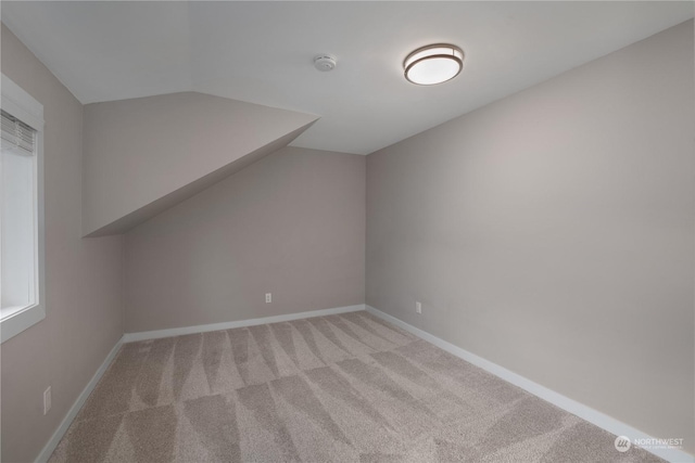 bonus room with light carpet and lofted ceiling