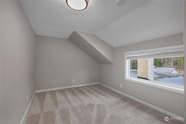 bonus room featuring light carpet and vaulted ceiling