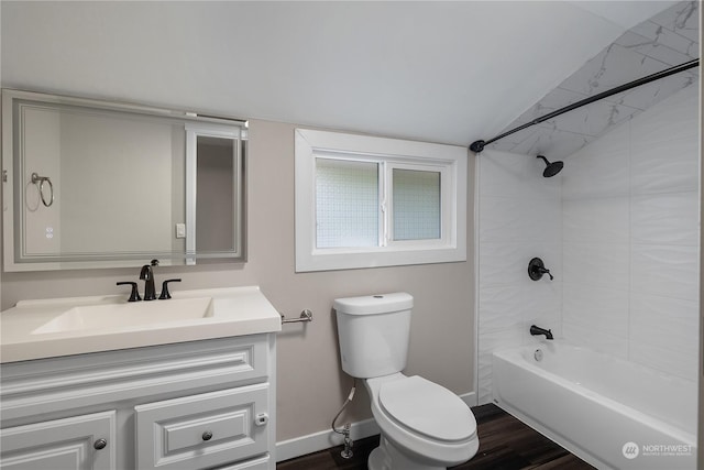 full bathroom featuring tiled shower / bath, vaulted ceiling, hardwood / wood-style floors, vanity, and toilet