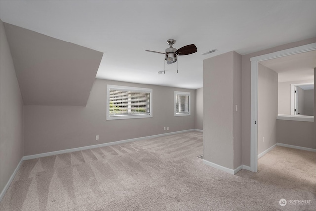 additional living space featuring lofted ceiling, light carpet, and ceiling fan