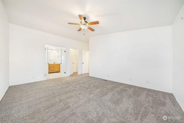 unfurnished bedroom with carpet floors, ceiling fan, and ensuite bathroom