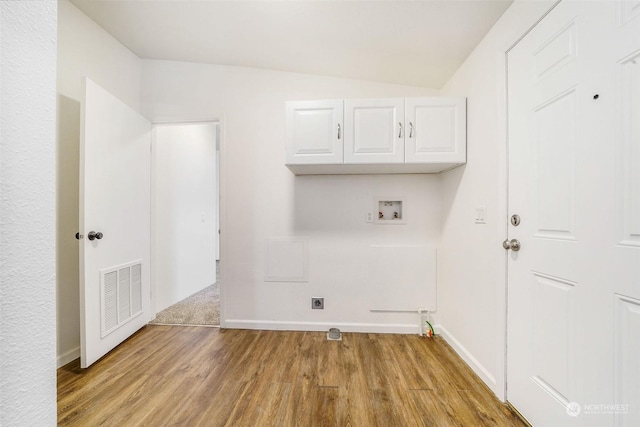 laundry area with hookup for a washing machine, electric dryer hookup, light wood-type flooring, and cabinets