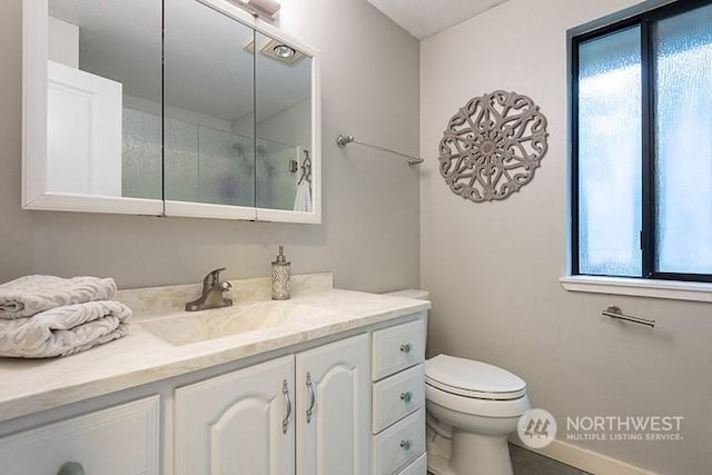 full bathroom with toilet, baseboards, a shower, and vanity