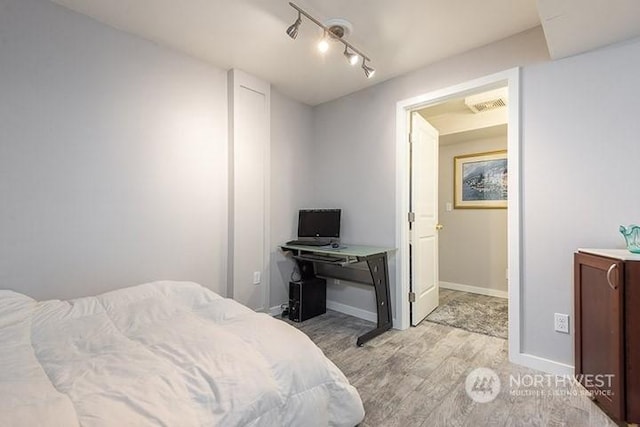 bedroom featuring baseboards, visible vents, and light wood-style floors