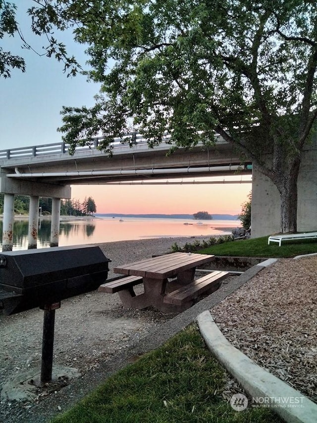 surrounding community featuring a water view and a boat dock