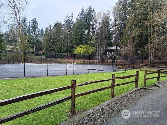 view of basketball court featuring a yard and fence