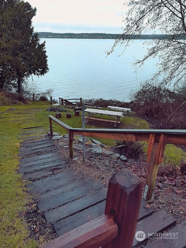 exterior space with a water view and a lawn