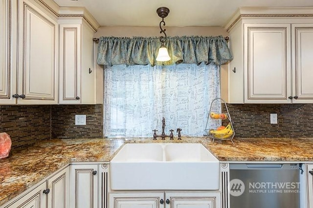 kitchen with light stone counters, a sink, stainless steel dishwasher, tasteful backsplash, and pendant lighting