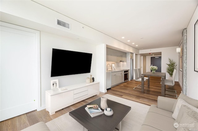 living room with sink and light hardwood / wood-style flooring