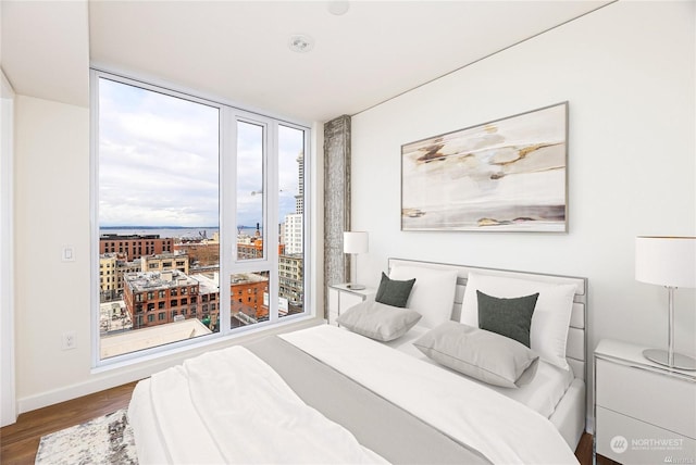 bedroom featuring hardwood / wood-style flooring and a wall of windows