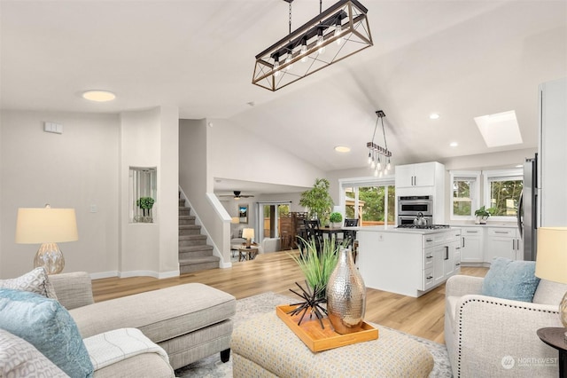 living room with vaulted ceiling with skylight and light wood-type flooring