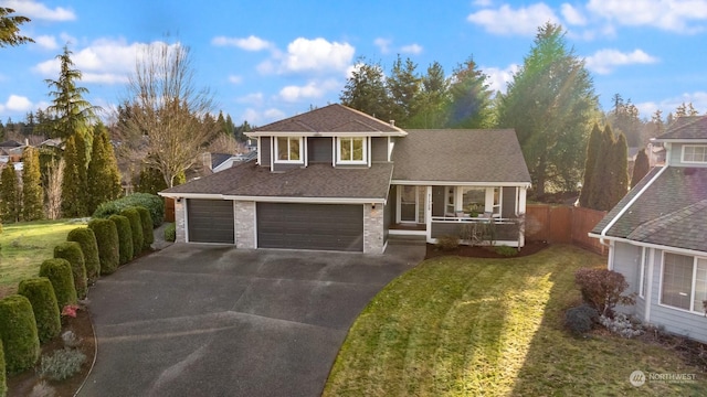 view of front of house featuring a porch, a garage, and a front yard