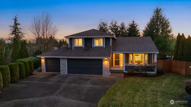 view of front of property featuring a garage and a lawn