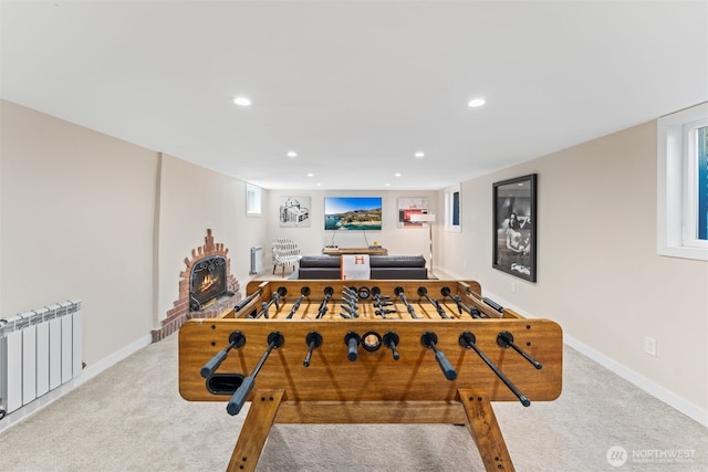 game room featuring light colored carpet, radiator heating unit, and a fireplace