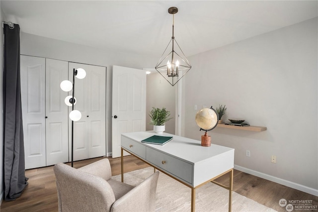 home office featuring wood-type flooring and a notable chandelier