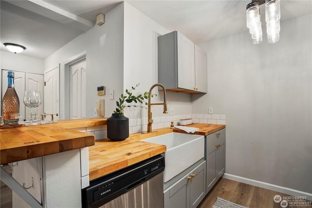 kitchen with gray cabinets, dark hardwood / wood-style floors, dishwasher, butcher block counters, and sink