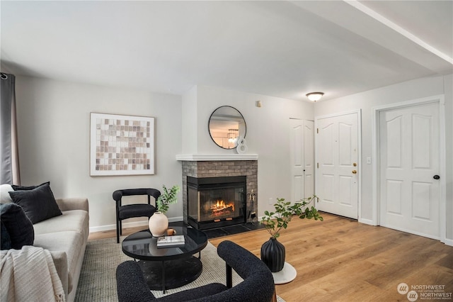 living room with wood-type flooring and a brick fireplace