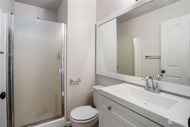 bathroom with vanity, toilet, and a shower with door