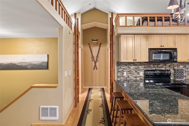 kitchen featuring pendant lighting, decorative backsplash, dark stone counters, black appliances, and light brown cabinets