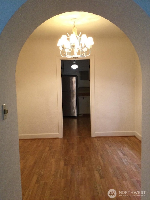 256 Burwell St, Bremerton, WA 98337 - unfurnished dining area with a chandelier, arched walkways, and wood finished floors
