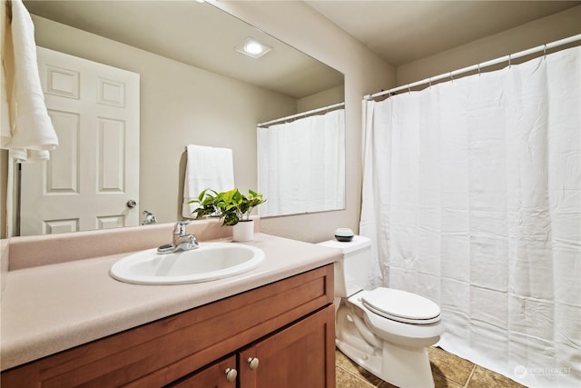 bathroom featuring vanity, tile patterned flooring, and toilet