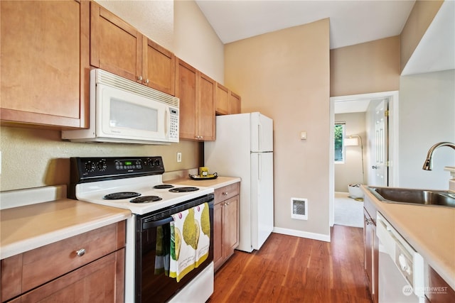 kitchen with sink, white appliances, and dark wood-type flooring