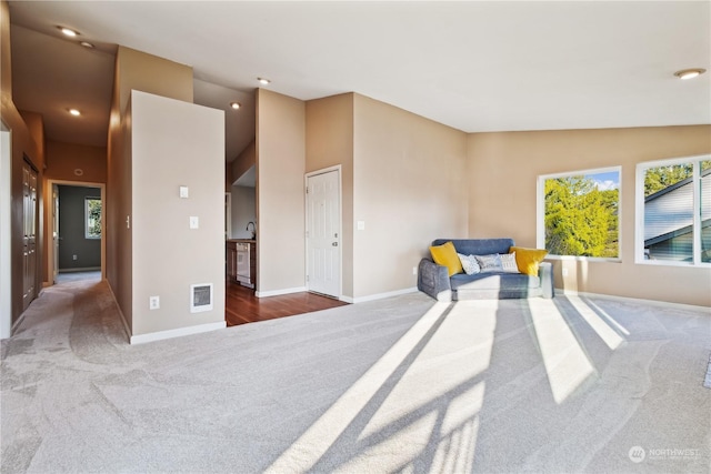 sitting room featuring vaulted ceiling and carpet