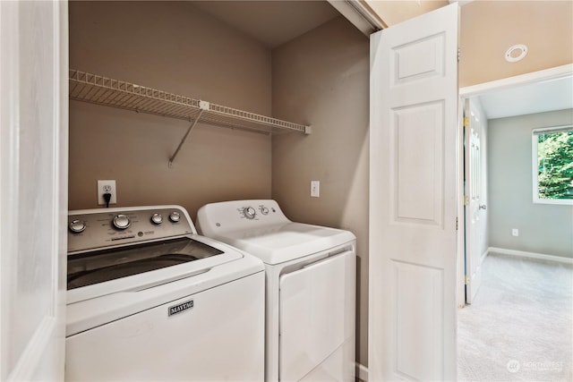 clothes washing area with separate washer and dryer and light carpet