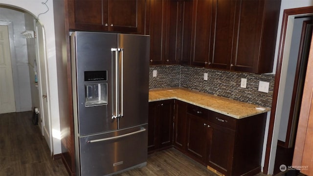 kitchen featuring dark hardwood / wood-style flooring, light stone countertops, decorative backsplash, and high quality fridge