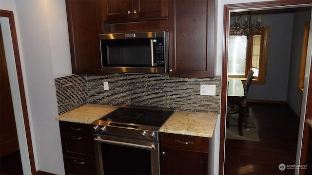 kitchen featuring light stone countertops, appliances with stainless steel finishes, dark brown cabinets, and decorative backsplash