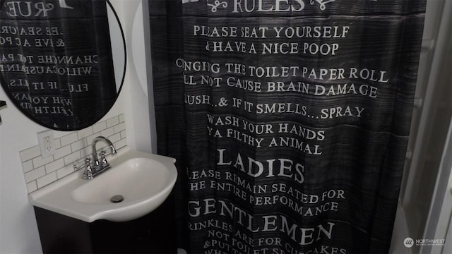 bathroom featuring sink, backsplash, and a shower with curtain