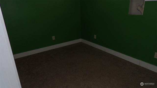 spare room with dark carpet