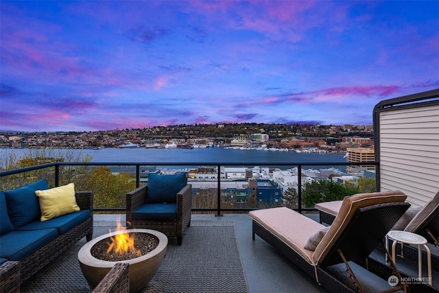 balcony at dusk featuring an outdoor living space with a fire pit