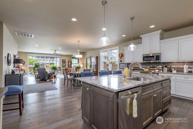 kitchen featuring sink, hanging light fixtures, white cabinets, and appliances with stainless steel finishes