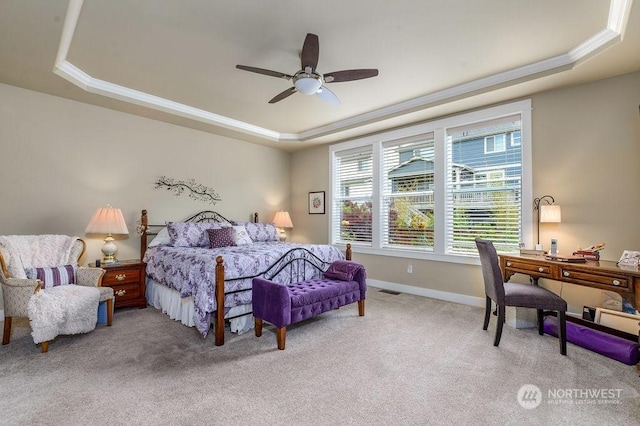 carpeted bedroom featuring crown molding, ceiling fan, and a raised ceiling