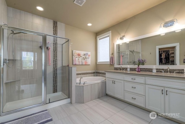 bathroom with vanity, tile patterned floors, and plus walk in shower