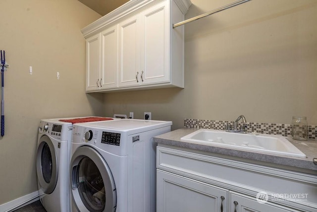 washroom with cabinets, sink, and washer and clothes dryer