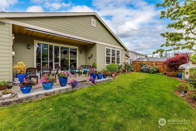 back of house with a lawn and a patio