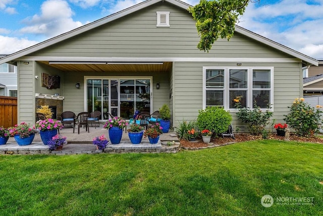 rear view of property with a yard and a patio area