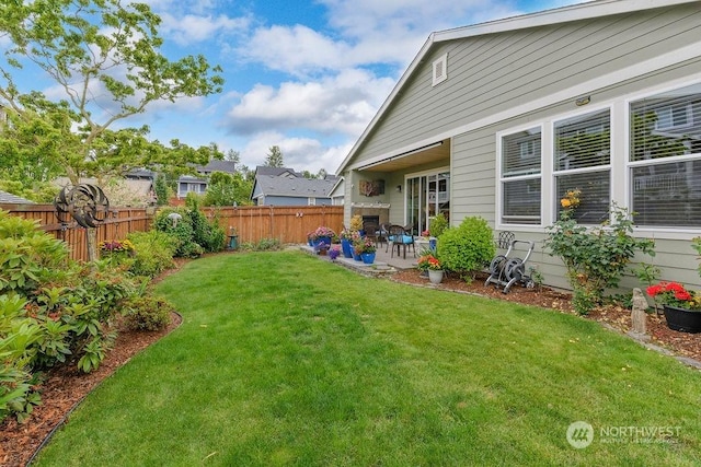 view of yard featuring a fireplace and a patio area