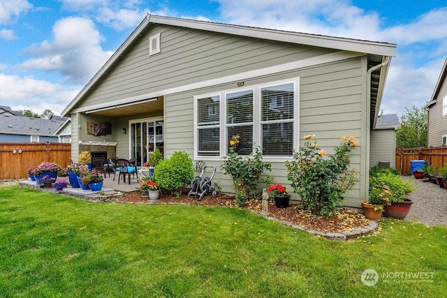 rear view of property with a yard and a patio area