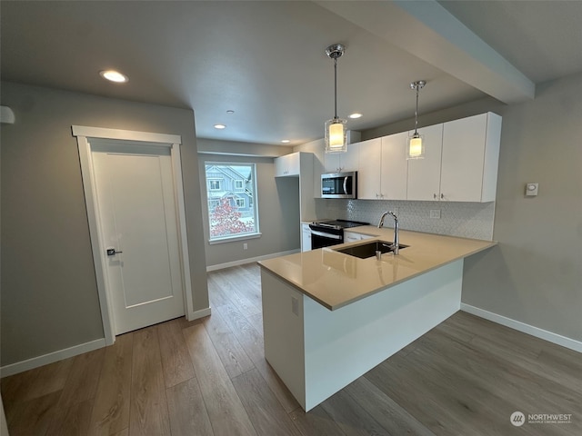 kitchen with decorative light fixtures, white cabinetry, sink, electric range, and kitchen peninsula