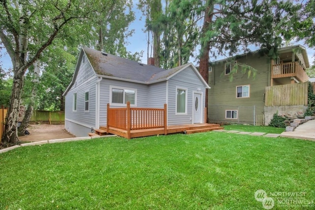 rear view of house featuring a yard and a deck