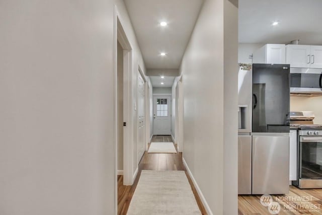 hallway with light hardwood / wood-style flooring