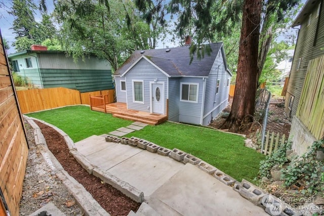 back of house featuring a wooden deck and a lawn