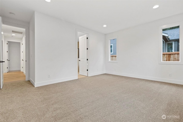 unfurnished room featuring light carpet, visible vents, baseboards, and recessed lighting