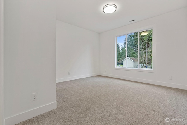 unfurnished room featuring carpet flooring, visible vents, and baseboards