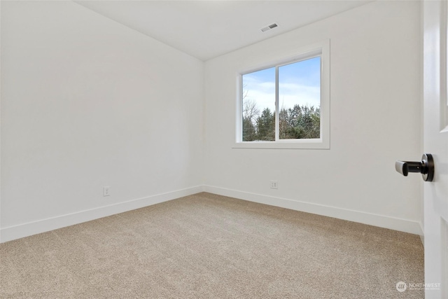 spare room featuring carpet, visible vents, and baseboards