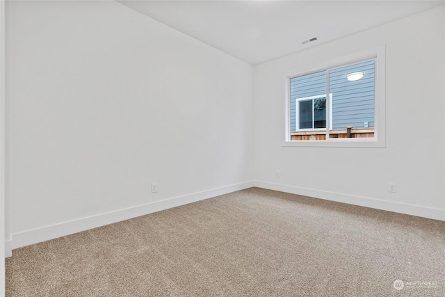 empty room with carpet floors, visible vents, and baseboards