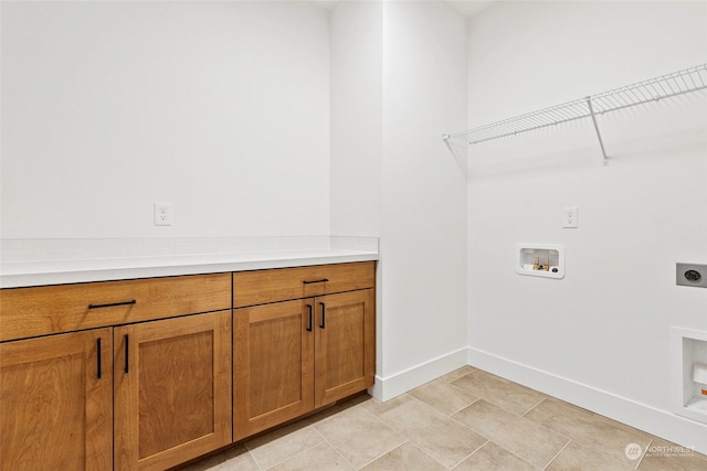 laundry area with cabinet space, light tile patterned floors, baseboards, hookup for a washing machine, and hookup for an electric dryer